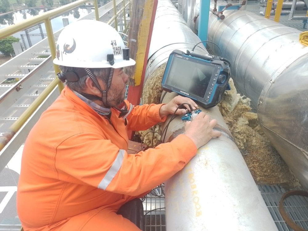 Inspector de Grupo Galicia realizando ultrasonido industrial sobre tubería con equipo portátil